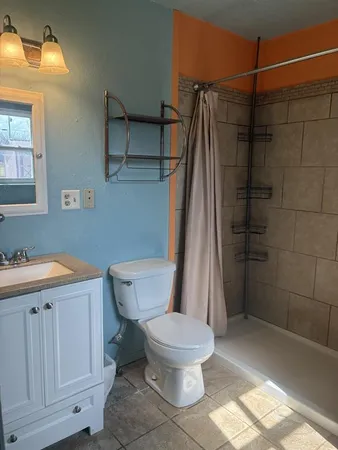 a bathroom with a toilet and a shower