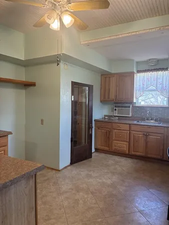 a kitchen with granite countertop a refrigerator and a stove top oven