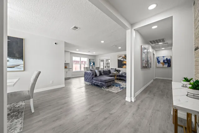 a living room with furniture and a wooden floor