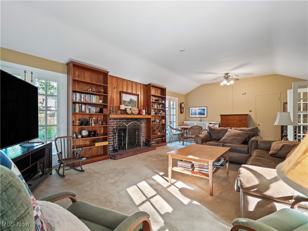 2842 Lee Road Cleveland, OH 44120 - Photo 15 of 44 Carpeted living area with healthy amount of natural light, vaulted ceiling, a brick fireplace, and a ceiling fan