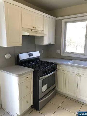 a kitchen with granite countertop white cabinets and a stove
