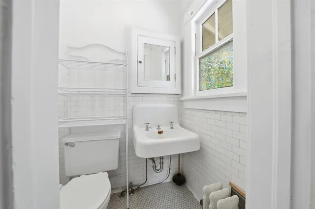a bathroom with a toilet a sink and mirror