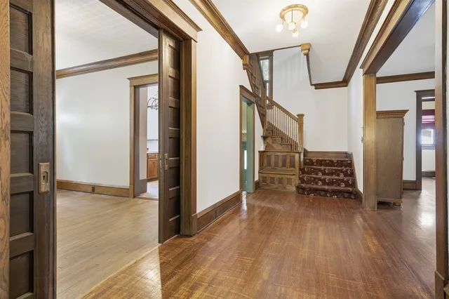 a view of entryway and hall with wooden floor