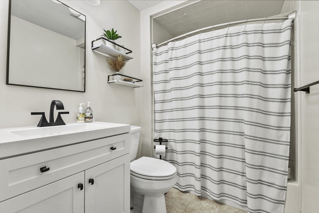 29 Maple Street, Unit C Canton, MA 02021 - Photo 16 of 27 a bathroom with a sink a toilet and shower curtain