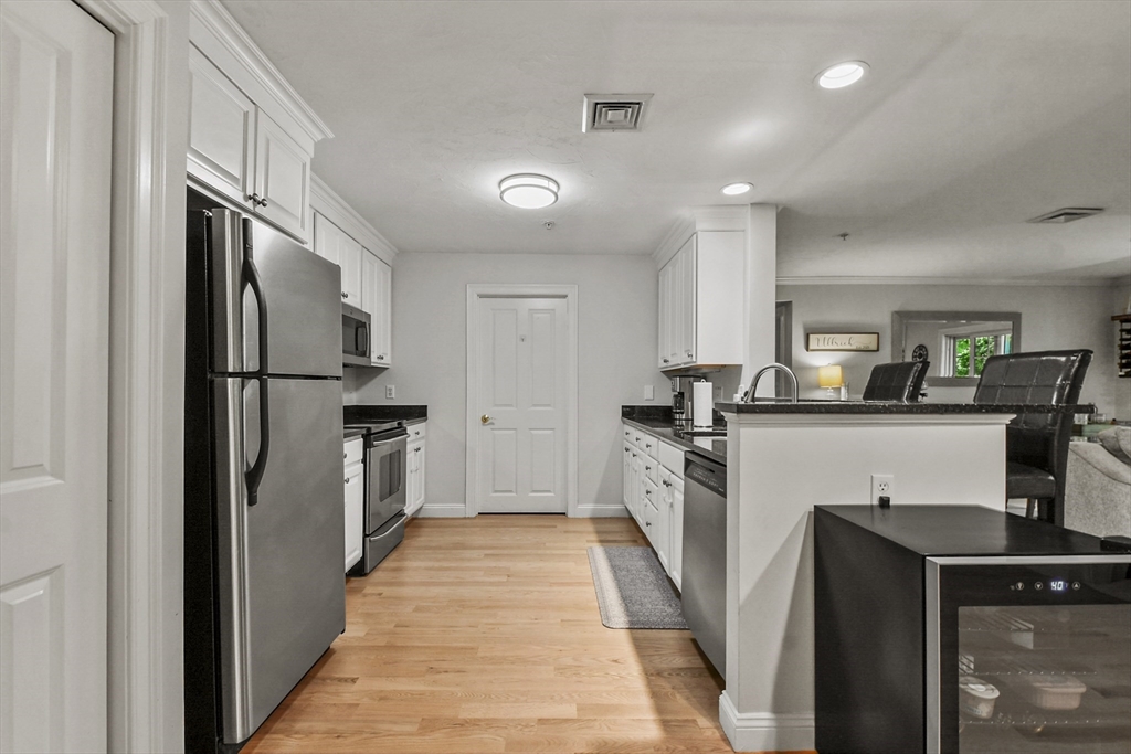 29 Maple Street, Unit C Canton, MA 02021 - Photo 7 of 27 a kitchen with refrigerator a sink and white cabinets