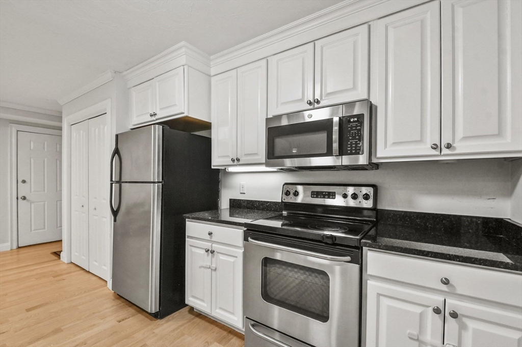 29 Maple Street, Unit C Canton, MA 02021 - Photo 8 of 27 a kitchen with cabinets stainless steel appliances and a wooden floors