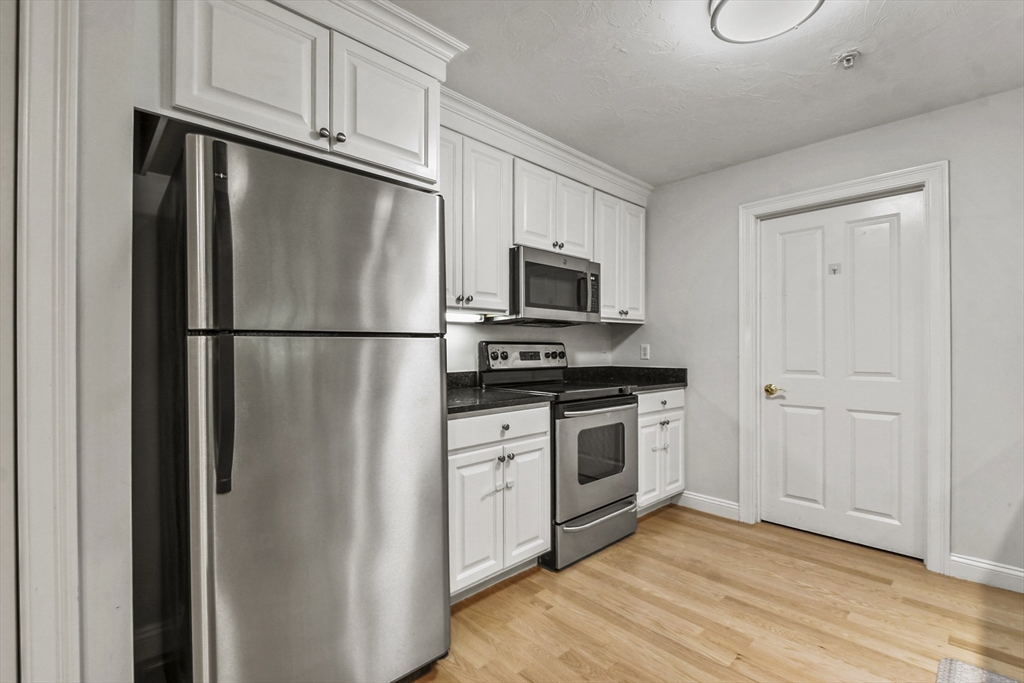 29 Maple Street, Unit C Canton, MA 02021 - Photo 9 of 27 a kitchen with stainless steel appliances a refrigerator stove and microwave