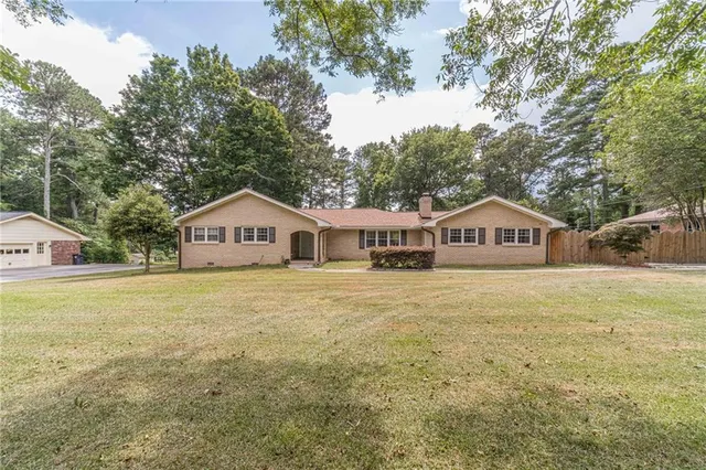 a front view of a house with yard and trees