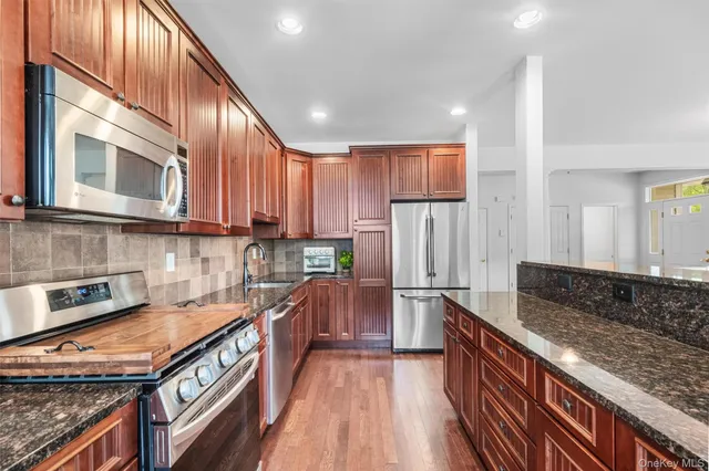 a kitchen with stainless steel appliances granite countertop a stove a sink and a microwave