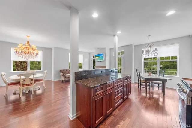 a kitchen with stainless steel appliances granite countertop a stove and a wooden floors