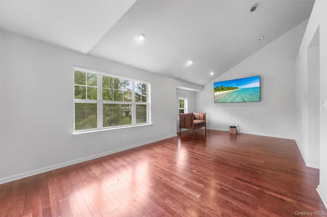 a view of a livingroom with wooden floor and furniture