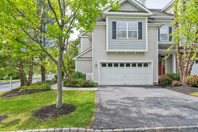 a front view of a house with yard and green space