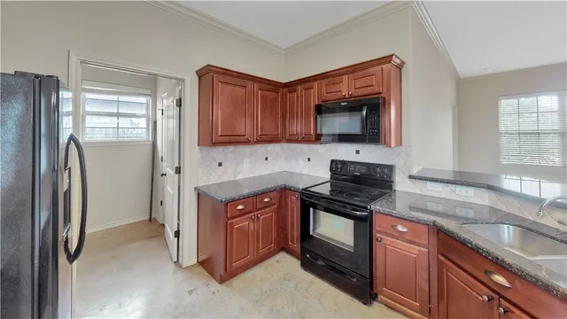 a kitchen with stainless steel appliances granite countertop a refrigerator stove and sink