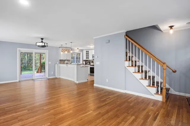 a view of empty room with wooden floor and windows