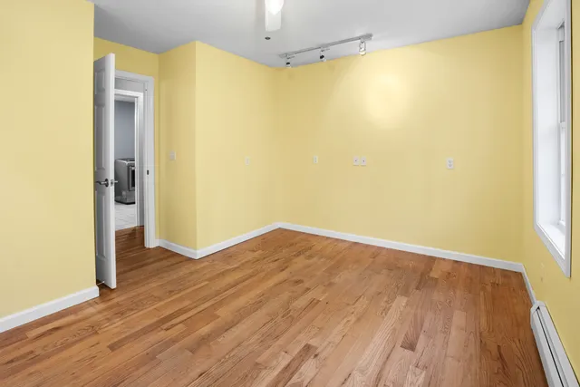 a view of a big room with wooden floor and entrance