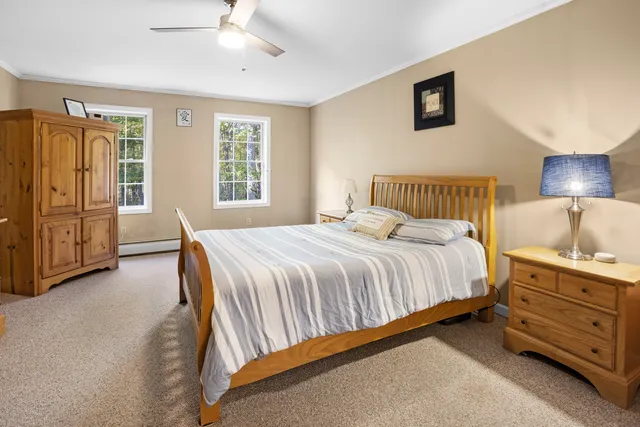 a spacious bedroom with a bed and a dresser