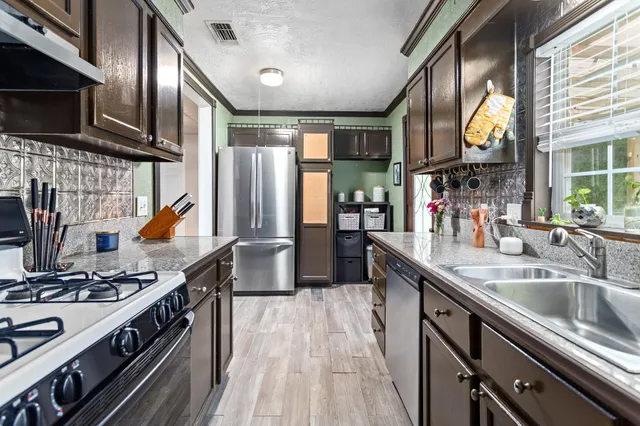 a kitchen with stainless steel appliances granite countertop a stove and a sink