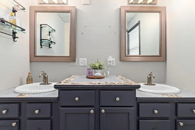 a bathroom with a granite countertop sink and a mirror