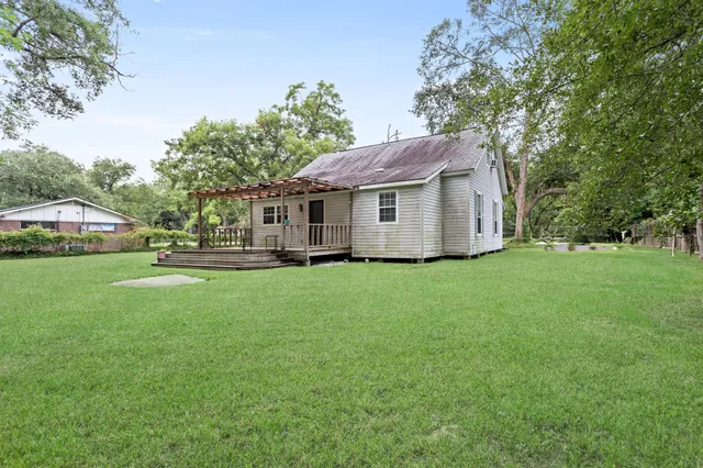 a view of a house with a backyard and a tree