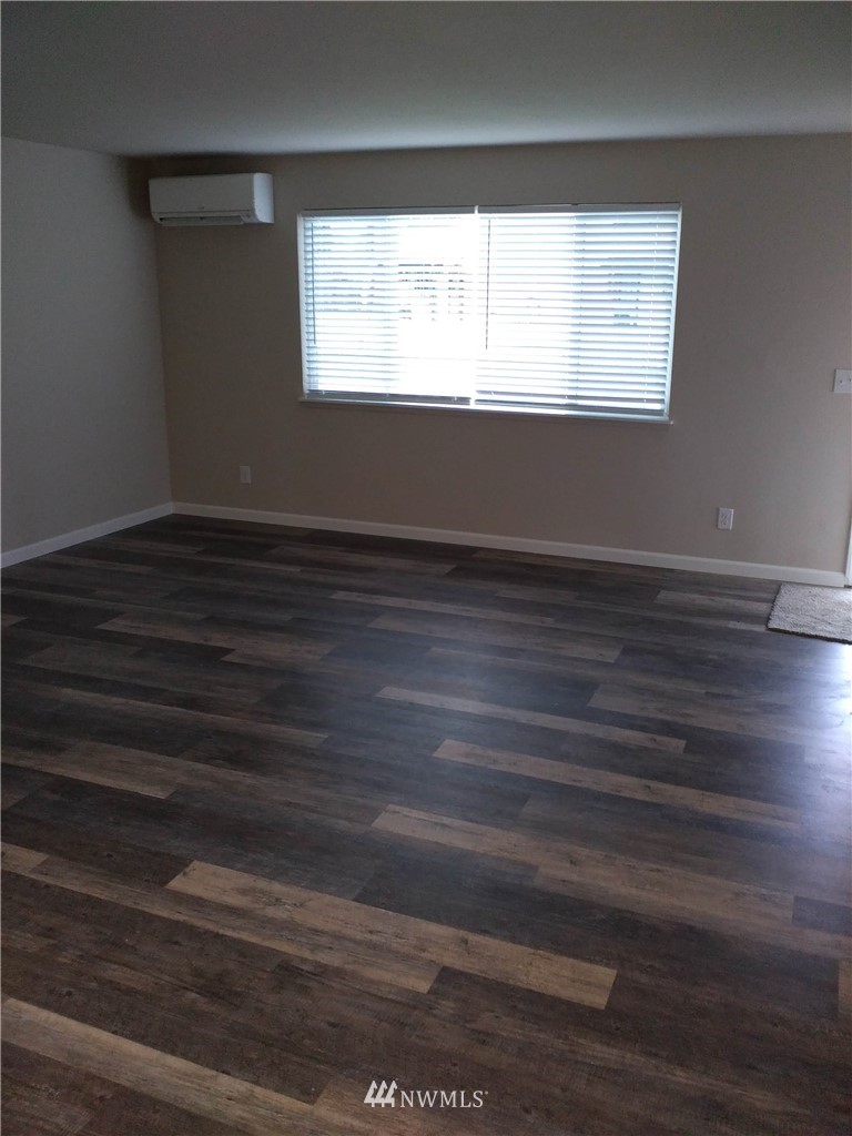 1141-1143 Magnuson Way Bremerton, WA 98310 - Photo 6 of 10 a view of an empty room with wooden floor and a window
