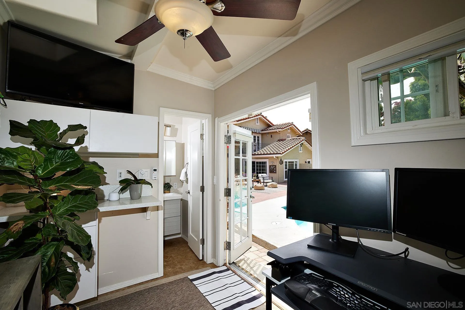 1548 Calle Violetas Encinitas, CA 92024 - Photo 42 of 47 a workstation with a computer on a desk and a book shelf