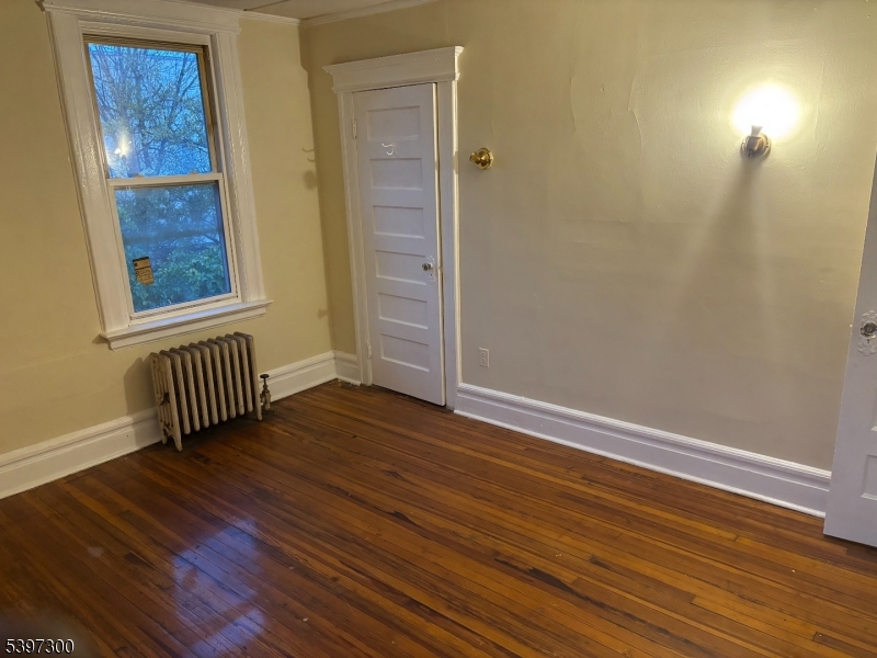100 Harrison Place, Unit 3 Irvington, NJ 07111 - Photo 3 of 17 a view of an empty room with wooden floor and a window