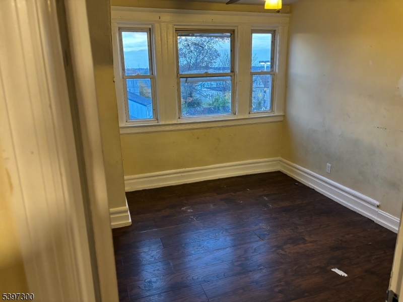 100 Harrison Place, Unit 3 Irvington, NJ 07111 - Photo 10 of 17 an empty room with wooden floor and windows