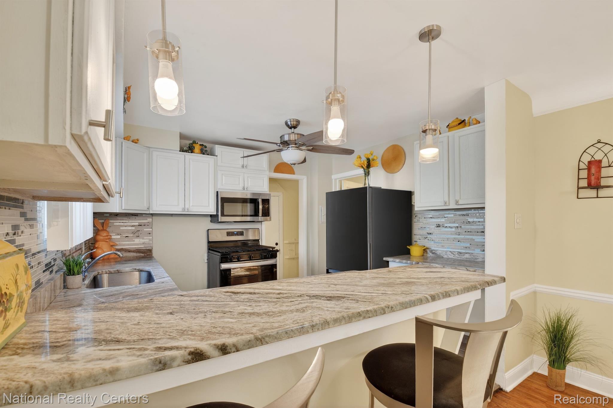 3956 Harvard Road Detroit, MI 48224 - Photo 17 of 44 Kitchen featuring decorative backsplash, stainless steel appliances, a breakfast bar area, and a peninsula