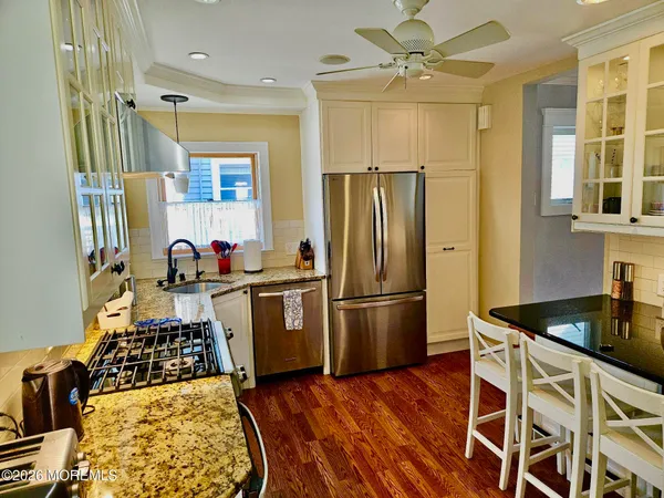 a kitchen with sink a refrigerator and wooden floor