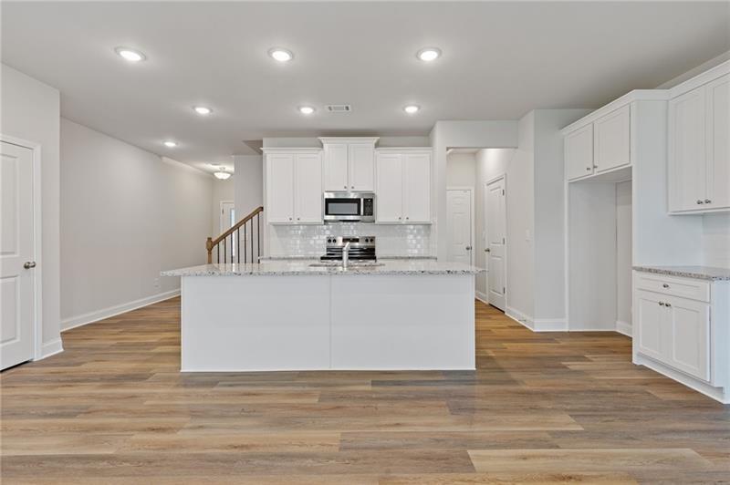 2208 Chant Street Dacula, GA 30019 - Photo 3 of 14 a view of kitchen with stainless steel appliances granite countertop a white stove top oven and white cabinets