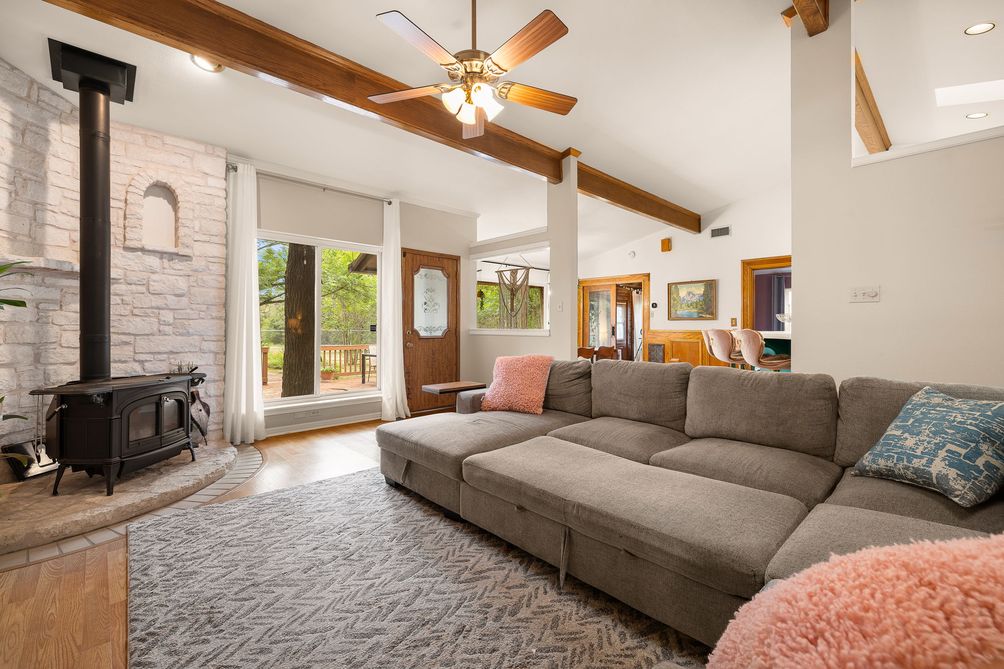 136 Valley View Road Georgetown, TX 78633 - Photo 1 of 40 Large living space with vaulted ceilings, wood beams, amazing views, newer wood stove for coziness during cold weather and open to dining and kitchen.