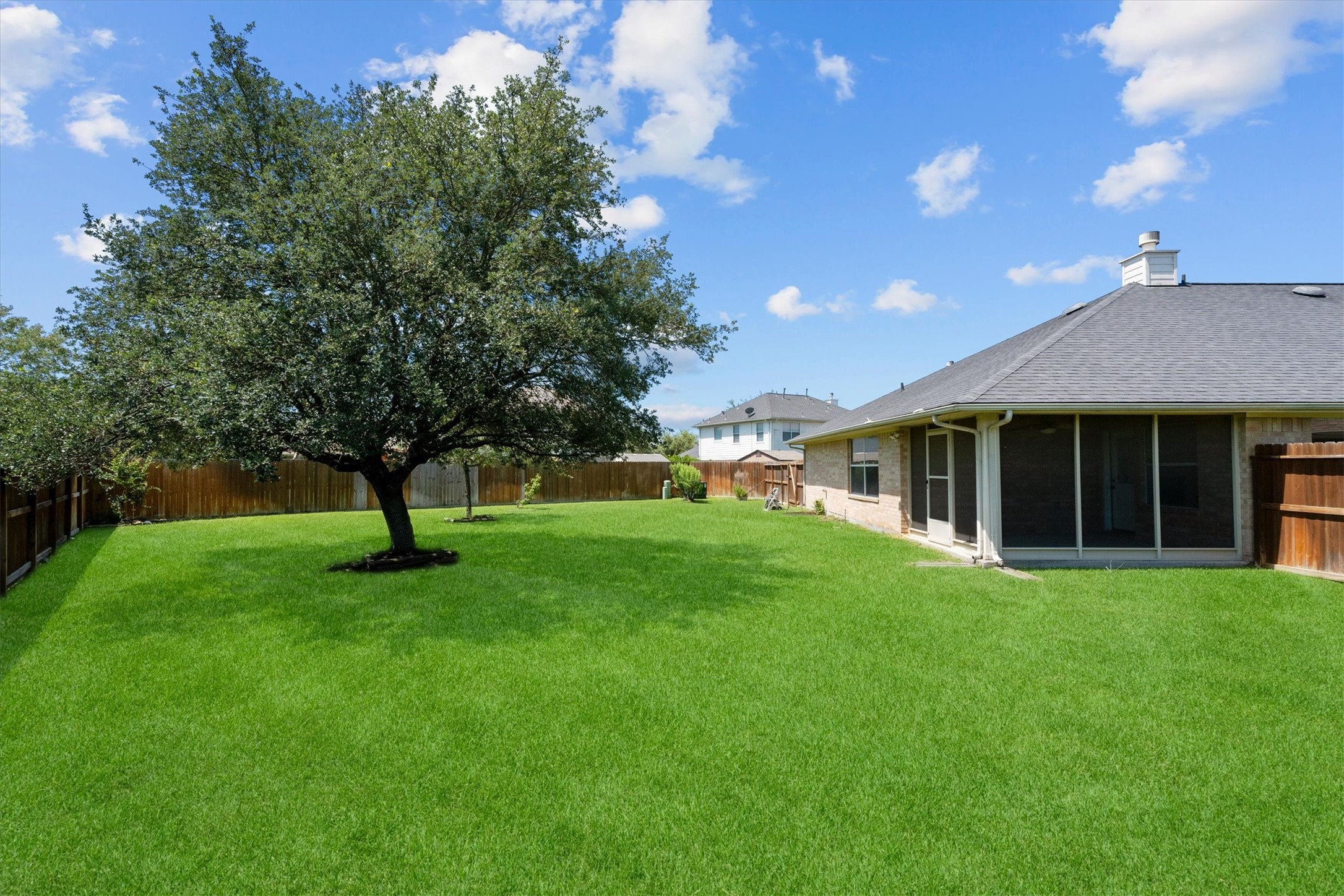 2507 Grayfeather Court Spring, TX 77388 - Photo 28 of 37 Large backyard with a lush green lawn, a large tree, and a wooden fence.