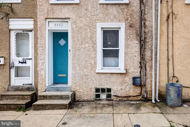 a front view of a house with a couple of potted plants