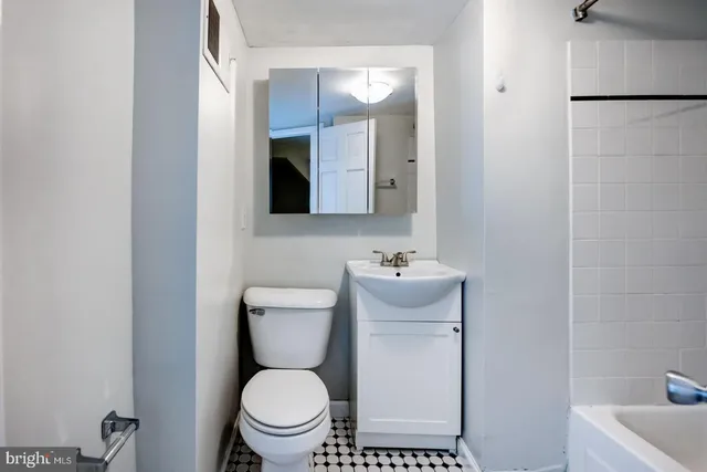 a bathroom with a toilet a sink and mirror