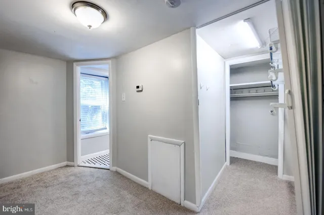 an empty room with closet and wooden door