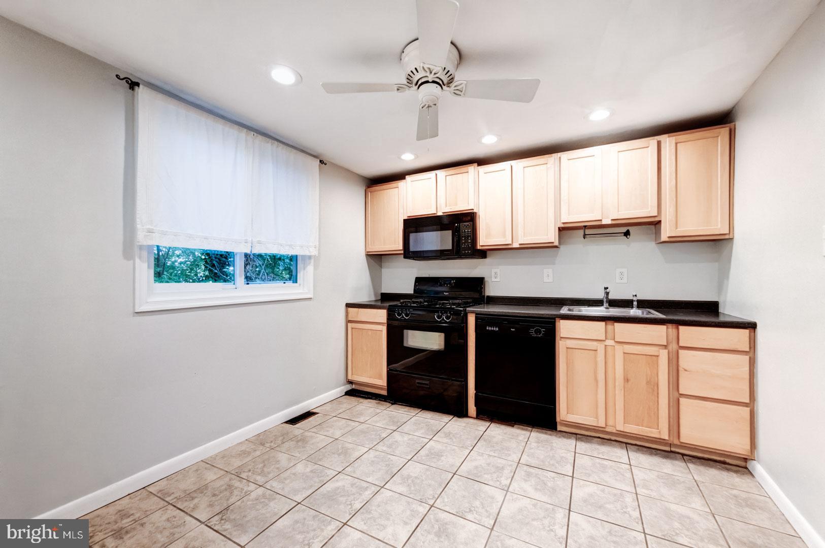 4442 Baker Street Philadelphia, PA 19127 - Photo 10 of 23 a kitchen with stainless steel appliances granite countertop a stove a sink and a microwave