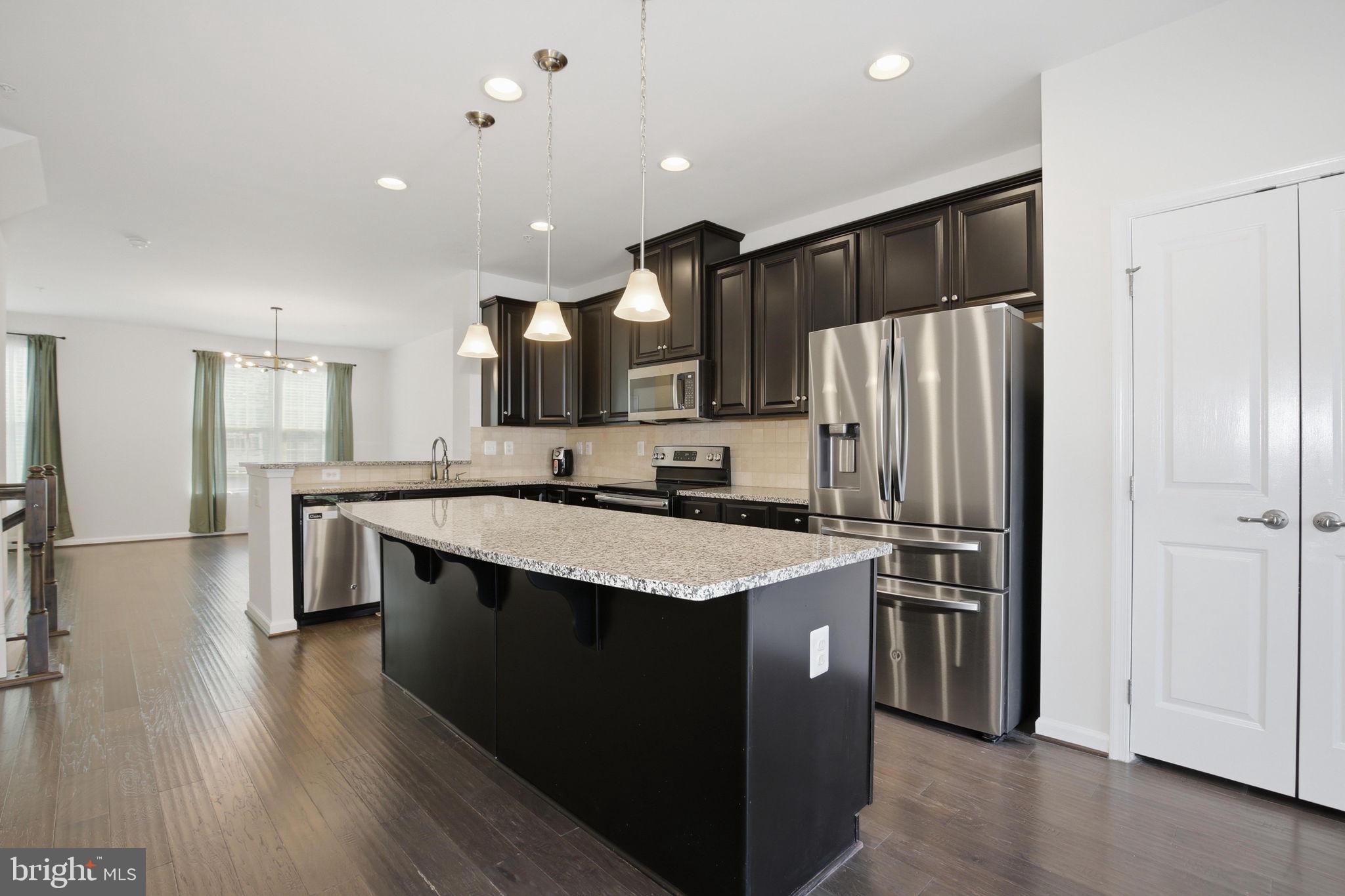 2784 Fredericksburg Road Hanover, MD 21076 - Photo 18 of 60 a kitchen with stainless steel appliances granite countertop a refrigerator a sink dishwasher a stove and white cabinets with wooden floor
