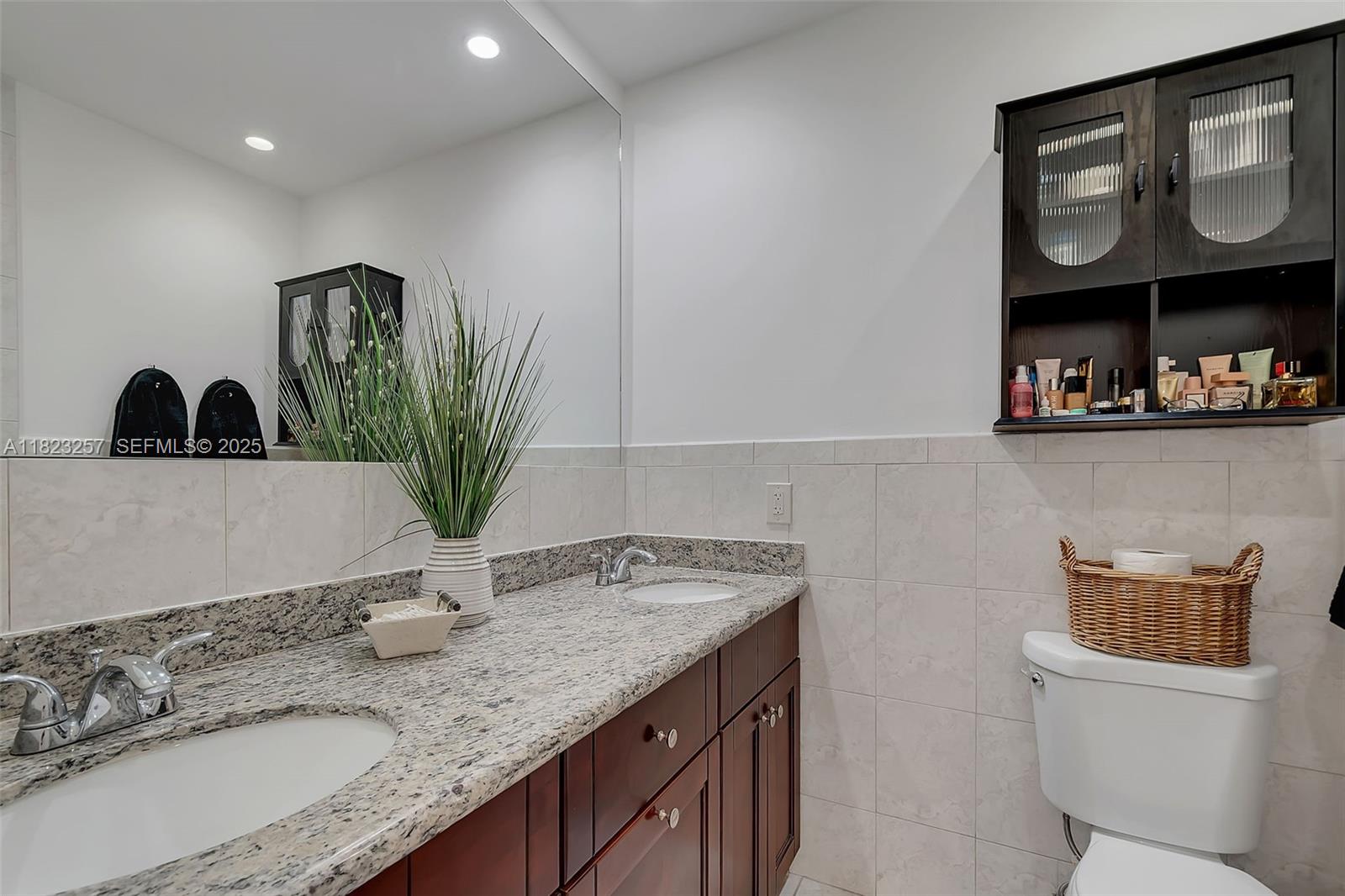 7340 Southwest 123rd Terrace Pinecrest, FL 33156 - Photo 16 of 30 a bathroom with a granite countertop sink and a mirror