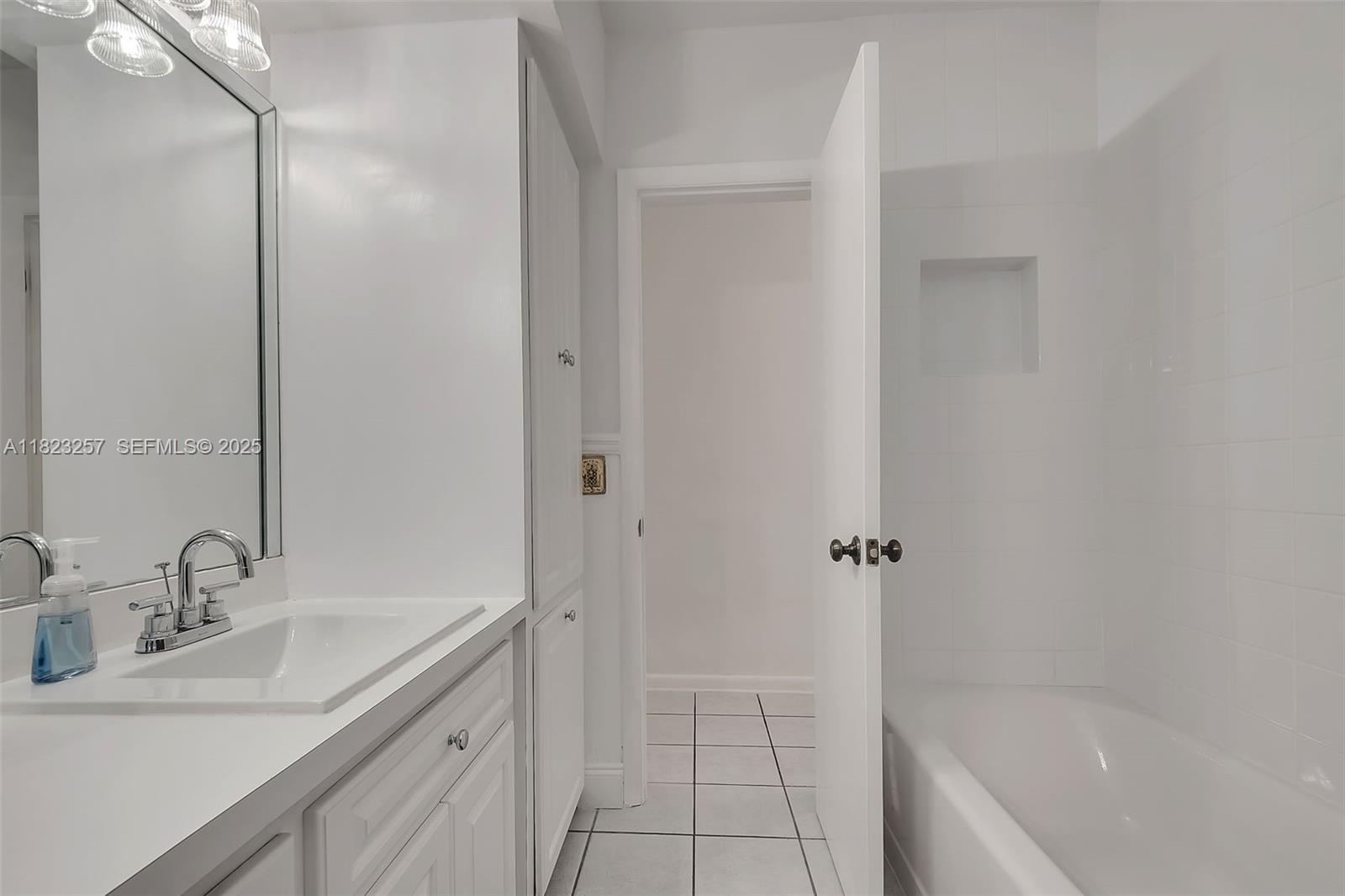7340 Southwest 123rd Terrace Pinecrest, FL 33156 - Photo 20 of 30 a bathroom with a tub shower sink vanity and a mirror