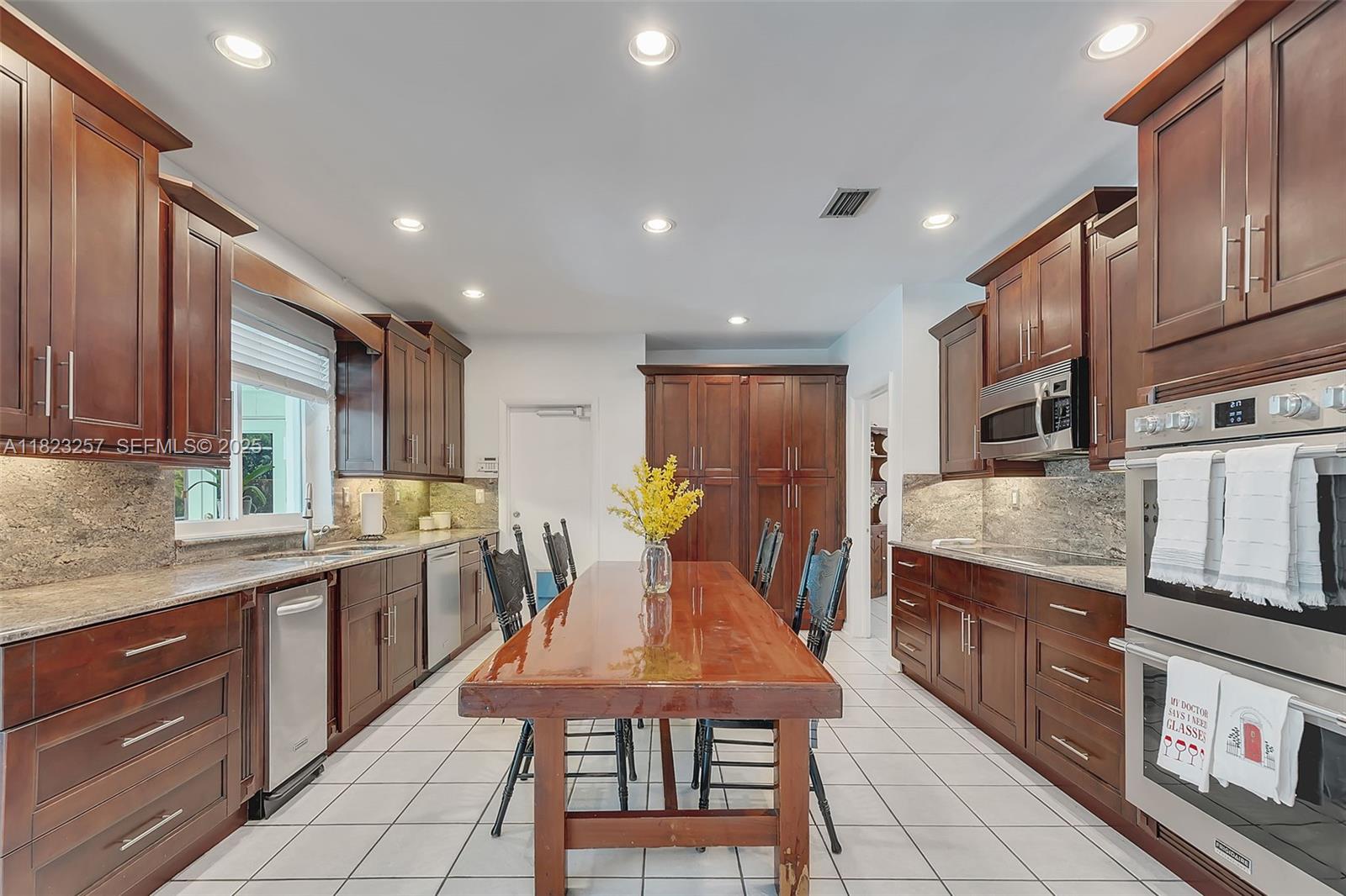 7340 Southwest 123rd Terrace Pinecrest, FL 33156 - Photo 7 of 30 a kitchen with stainless steel appliances granite countertop lots of counter top space and wooden floor