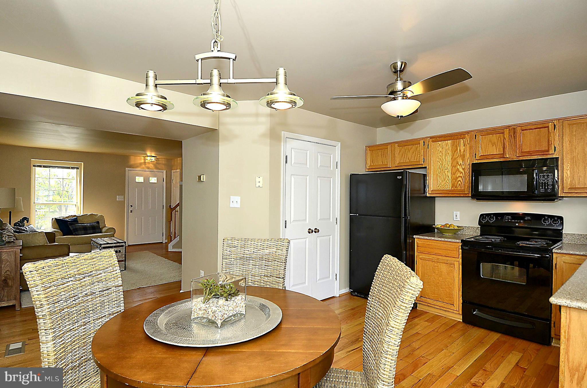 6405 Racetec Court Springfield, VA 22150 - Photo 8 of 30 a kitchen with stainless steel appliances granite countertop a sink a stove a dining table and chairs