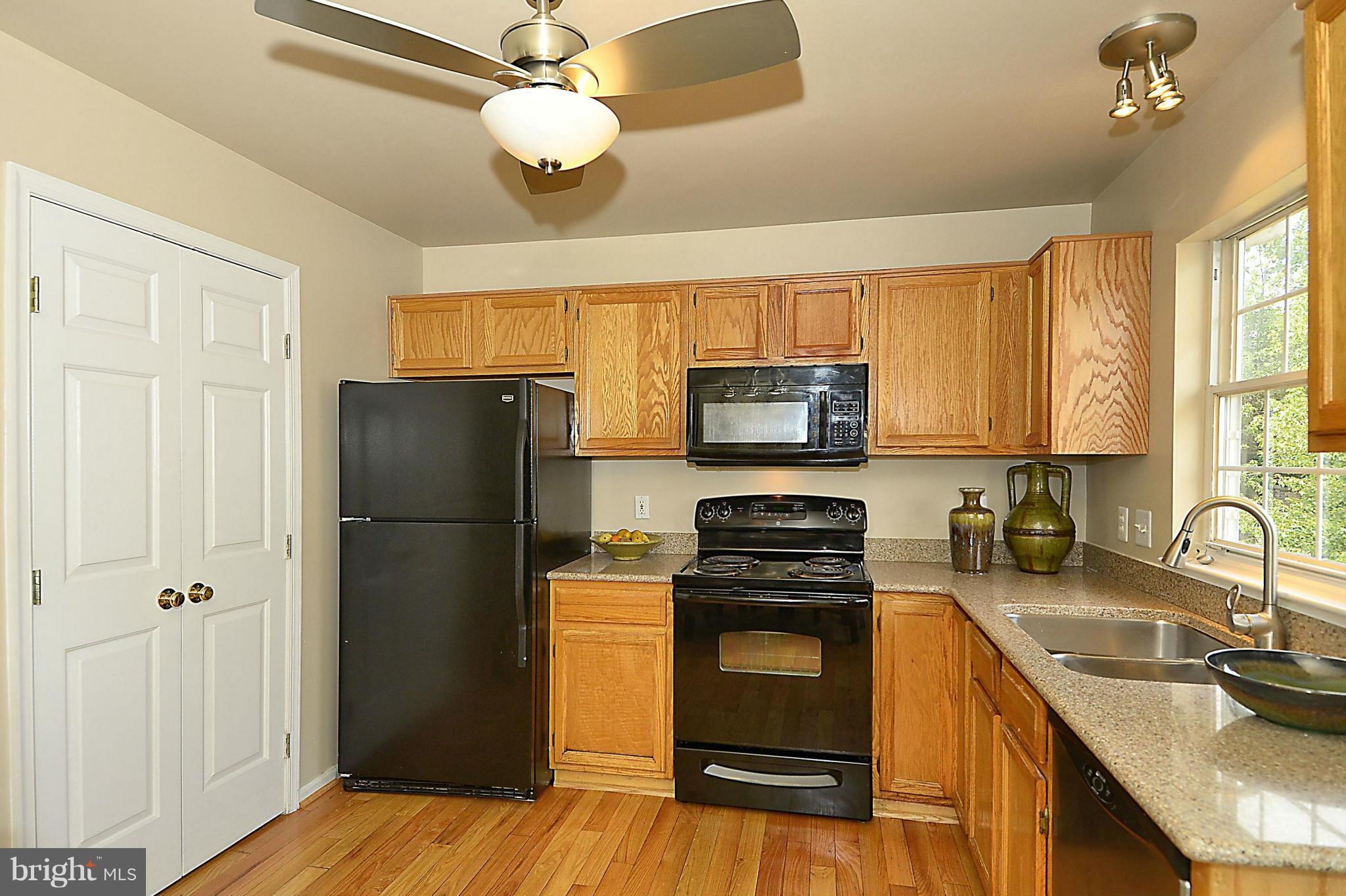 6405 Racetec Court Springfield, VA 22150 - Photo 10 of 30 a kitchen with a refrigerator a stove top oven a sink and dishwasher with wooden floor