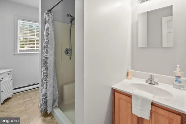 a bathroom with a shower sink and mirror