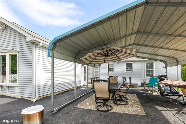 a patio with table and chairs and potted plants