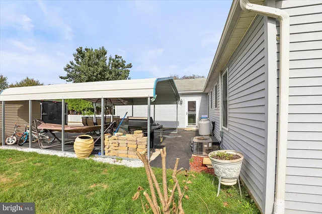 a view of a patio with table and chairs potted plants and floor to ceiling window