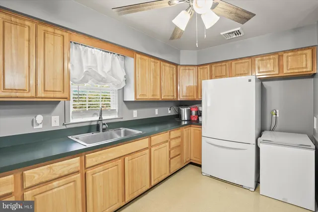 a kitchen with a refrigerator a sink and cabinets