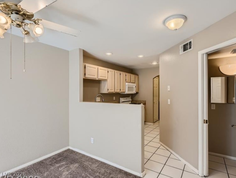 3950 South Sandhill Road, Unit 121 Las Vegas, NV 89121 - Photo 8 of 11 A compact kitchen with sleek appliances and ample cabinet space seamlessly connects to the adjacent room.