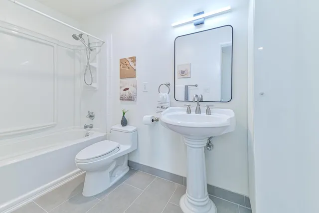 a bathroom with a toilet sink and a mirror