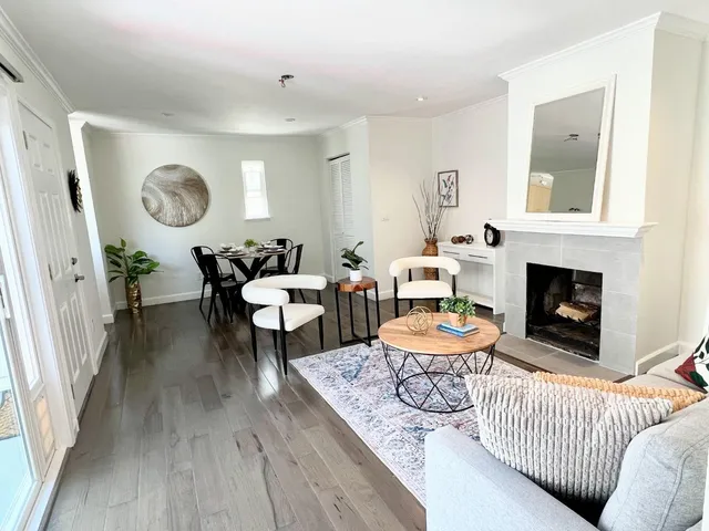 a living room with furniture a fireplace and a large window