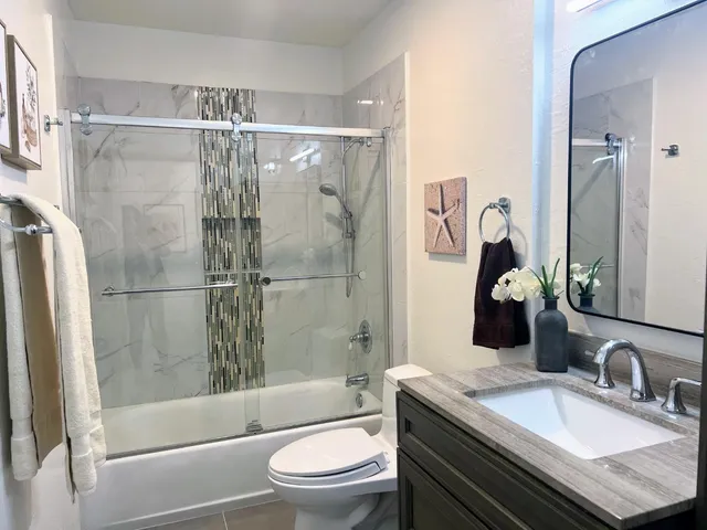 a bathroom with a sink a toilet and shower
